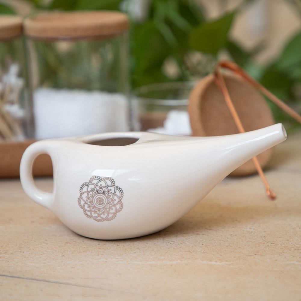 Experience the beauty and functionality of this cute glazed ceramic Neti pot, adorned with a mandala design. Available at Vayu Living.